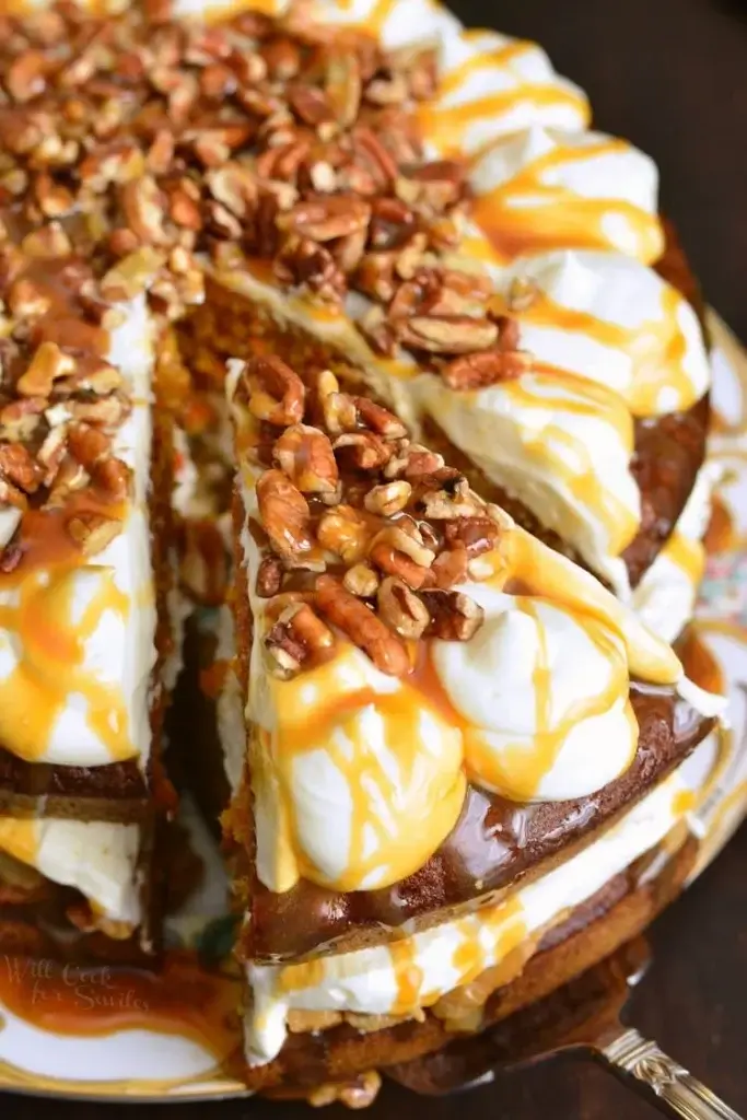 carrot cake topped with apple, caramel, and nuts