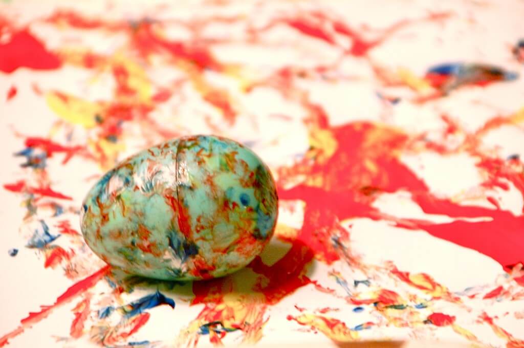 multicolored egg on a paper covered in paint