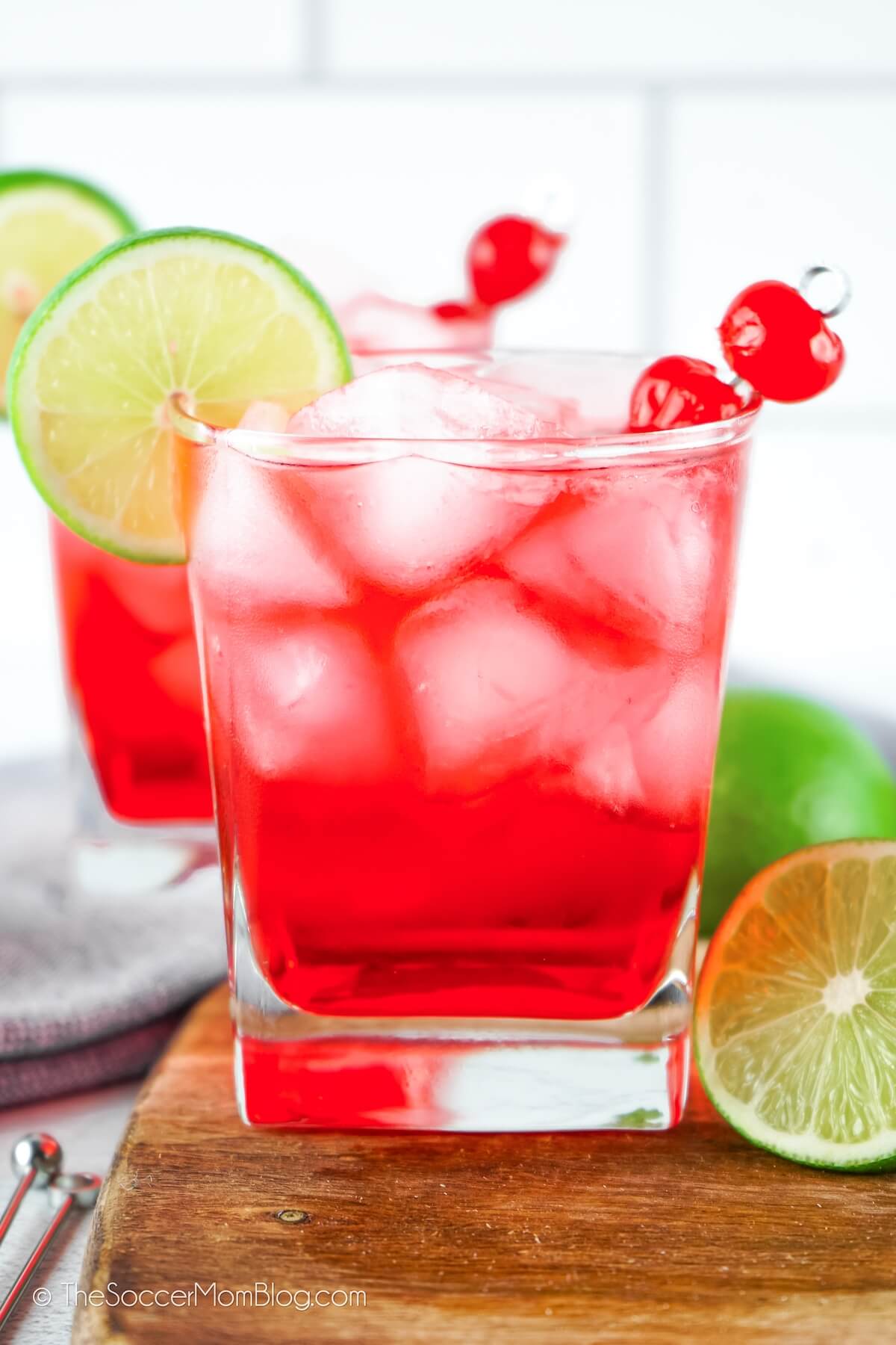 bright red Dirty Shirley cocktail garnished with cherry and lime