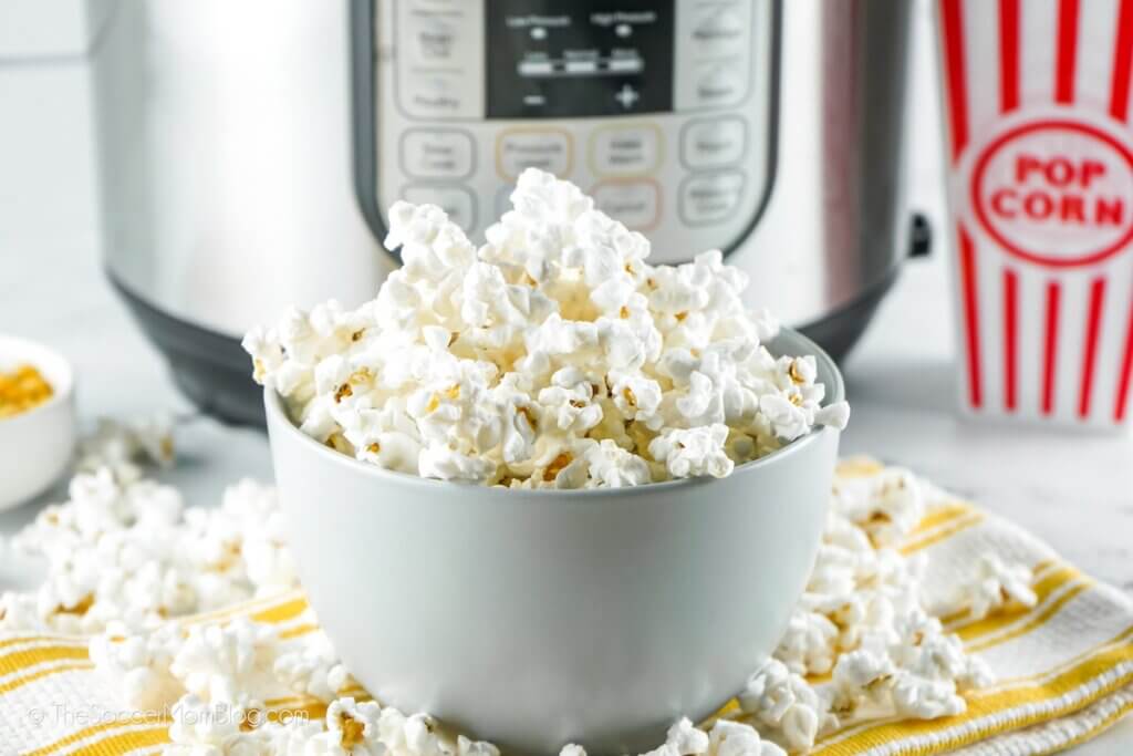 bowl of freshly popped Instant Pot popcorn with movie popcorn container
