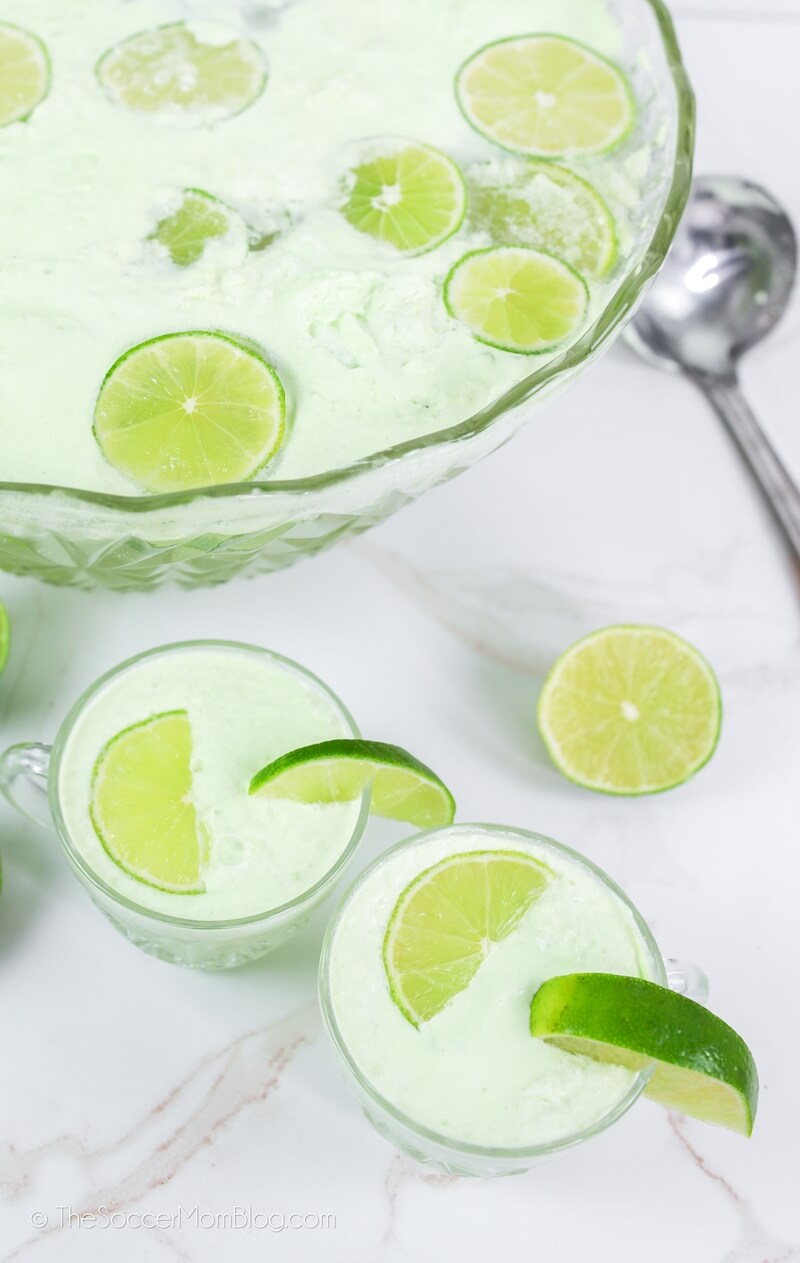top down view of a punch bowl with lime sherbet and limes