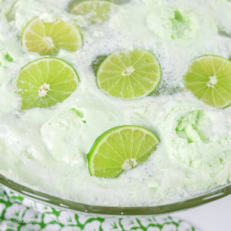 punch bowl with lime sherbet and sliced limes floating on top