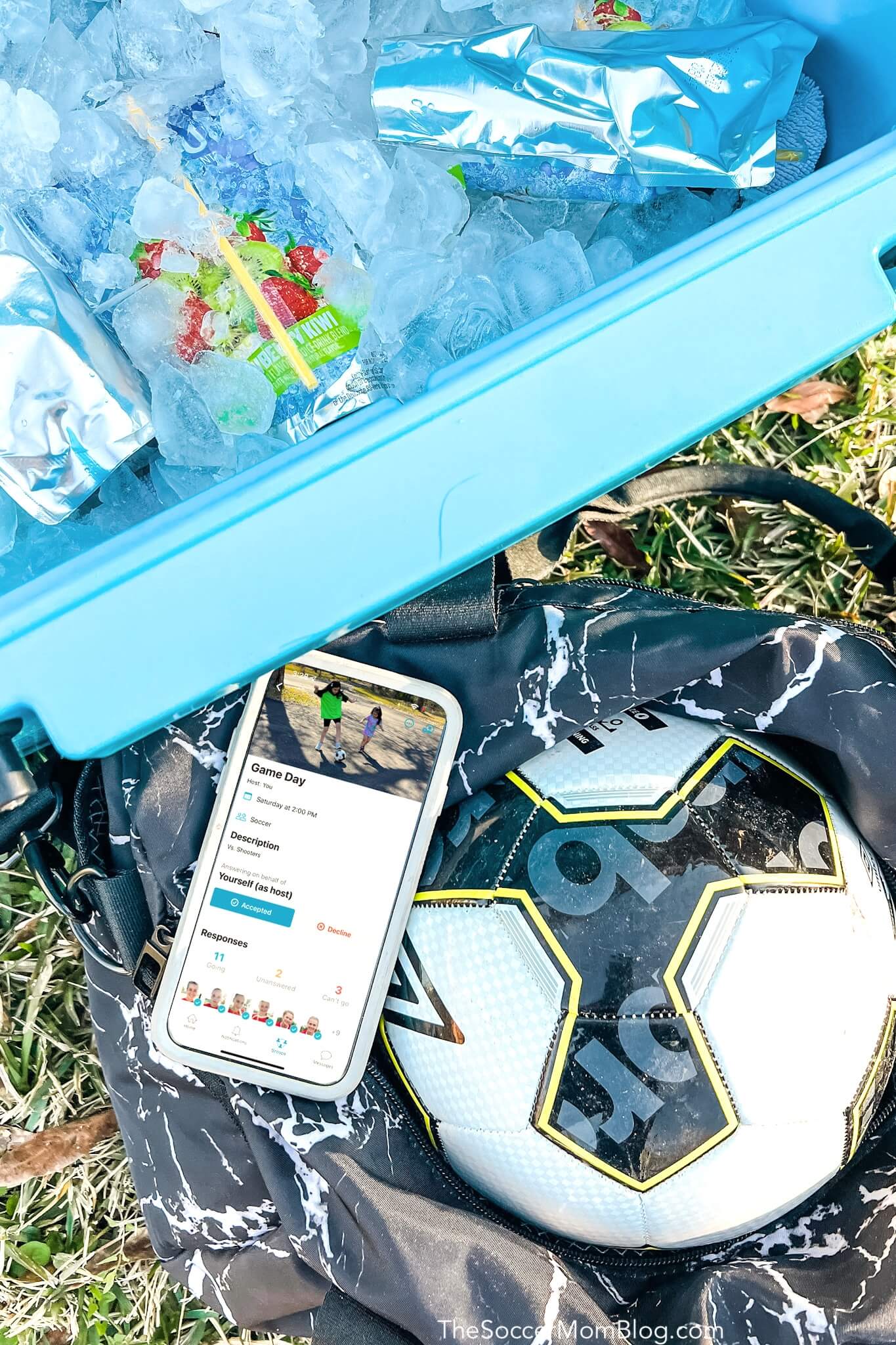 cooler with drinks, soccer ball, and phone with Spond app screen open