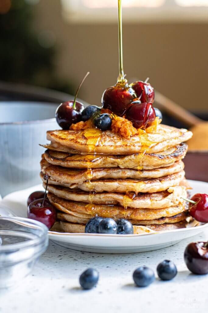 stack of pancakes with cherries and blueberries