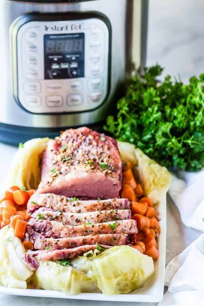 sliced corned beef and veggies in front of Instant Pot