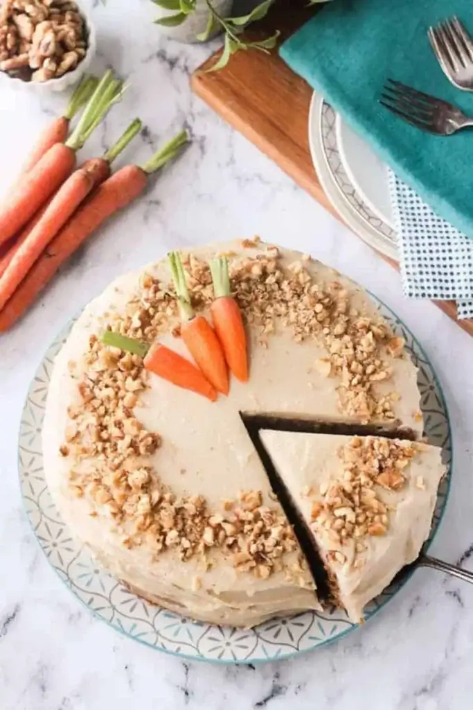 taking a slice out of a frosted vegan carrot cake