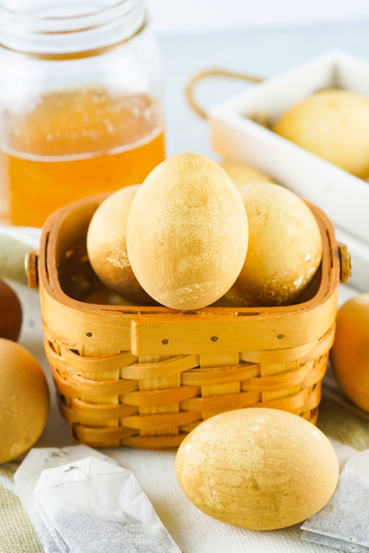 soft orange eggs in a basket, mason jar of tea in background