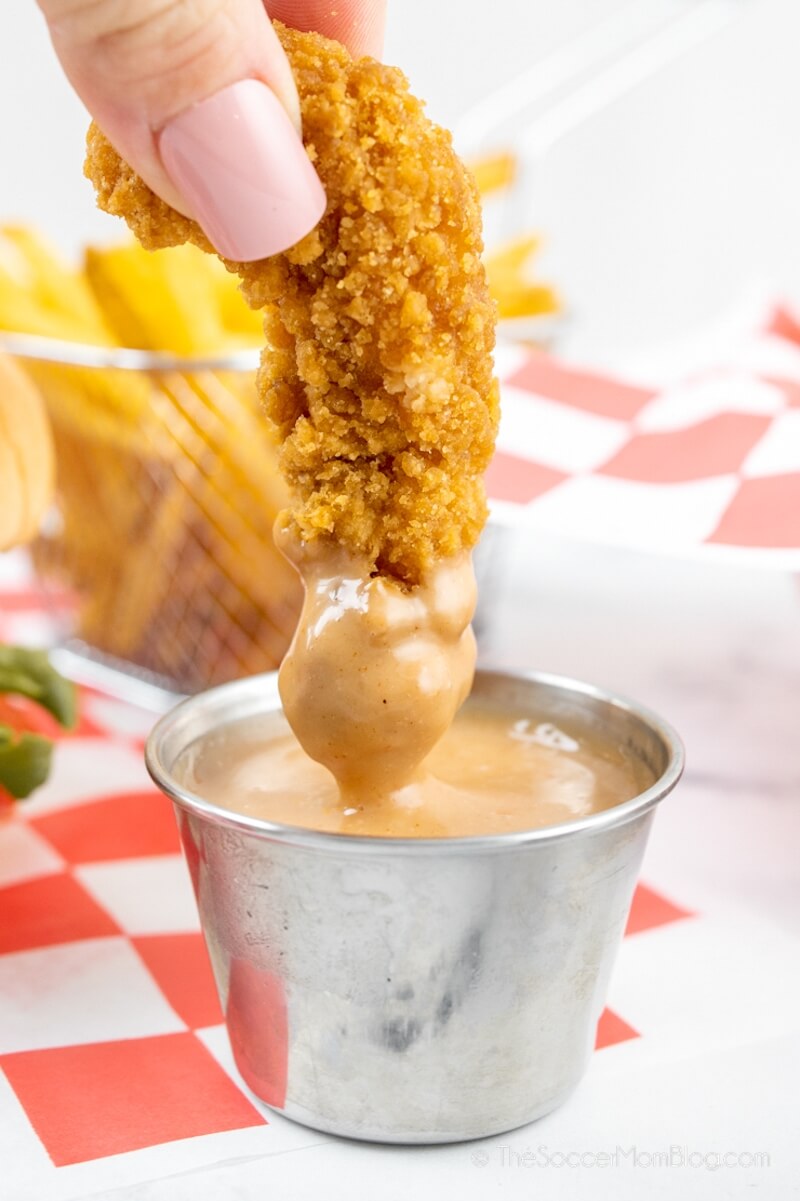 dipping a chicken tender in sauce