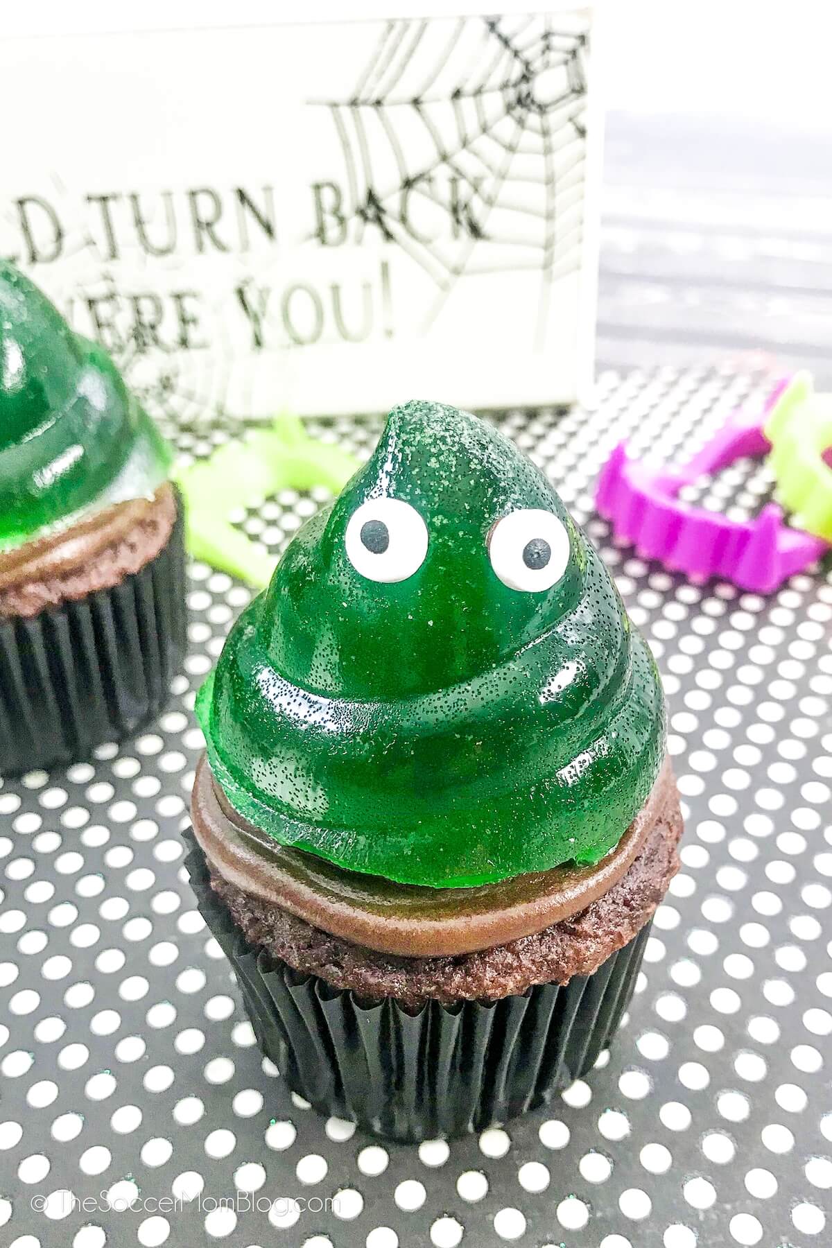 chocolate cupcakes with a green jello slime monster on top