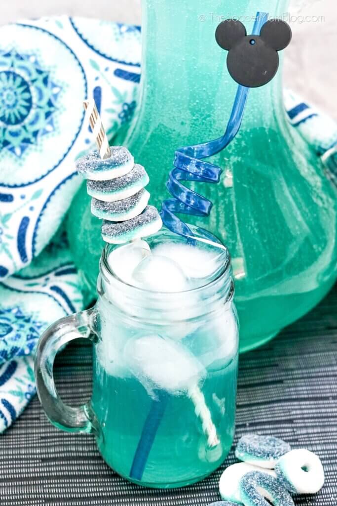 Cinderella Cooler Mocktail- a bright blue drink with candy ring garnish