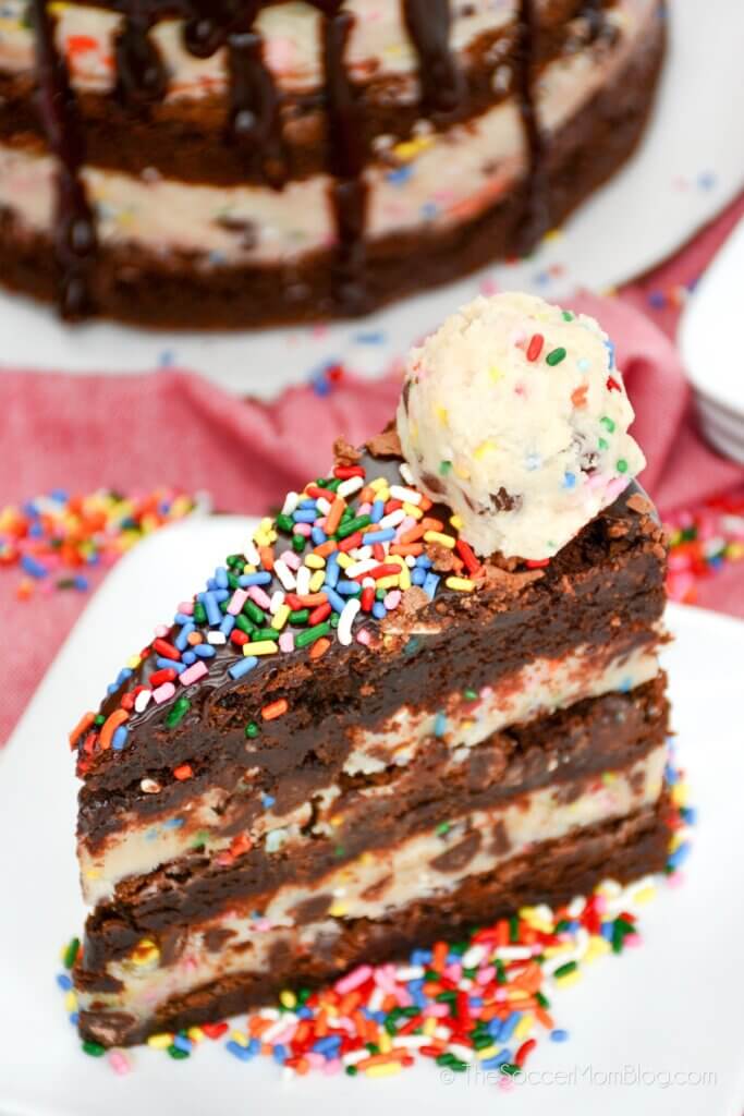A slice of Brownie Cookie Dough Cake on a white plate