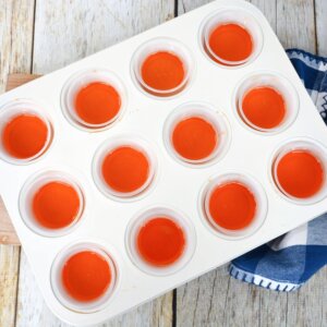 orange jello shots in a muffin tin