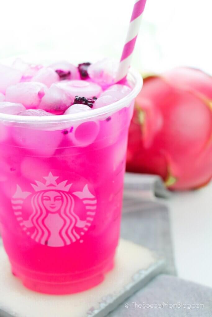 Mango Dragonfruit Refresher with a striped straw and fruit in background