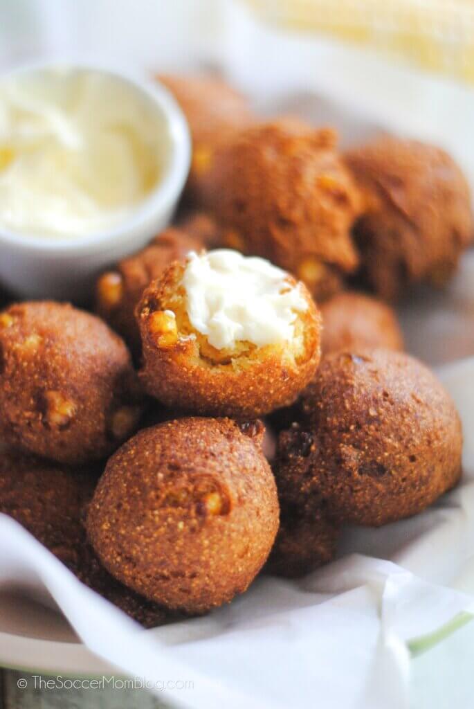 basket of hush puppies, one dipped in butter