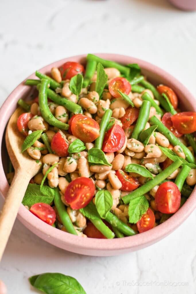 Mediterranean Bean Salad viewed from above, with wooden spoon