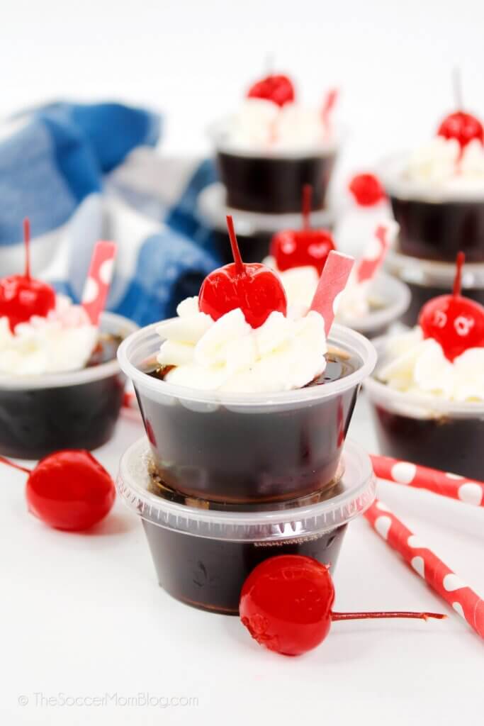 root beer flavored jello shots topped with whipped cream and a cherry