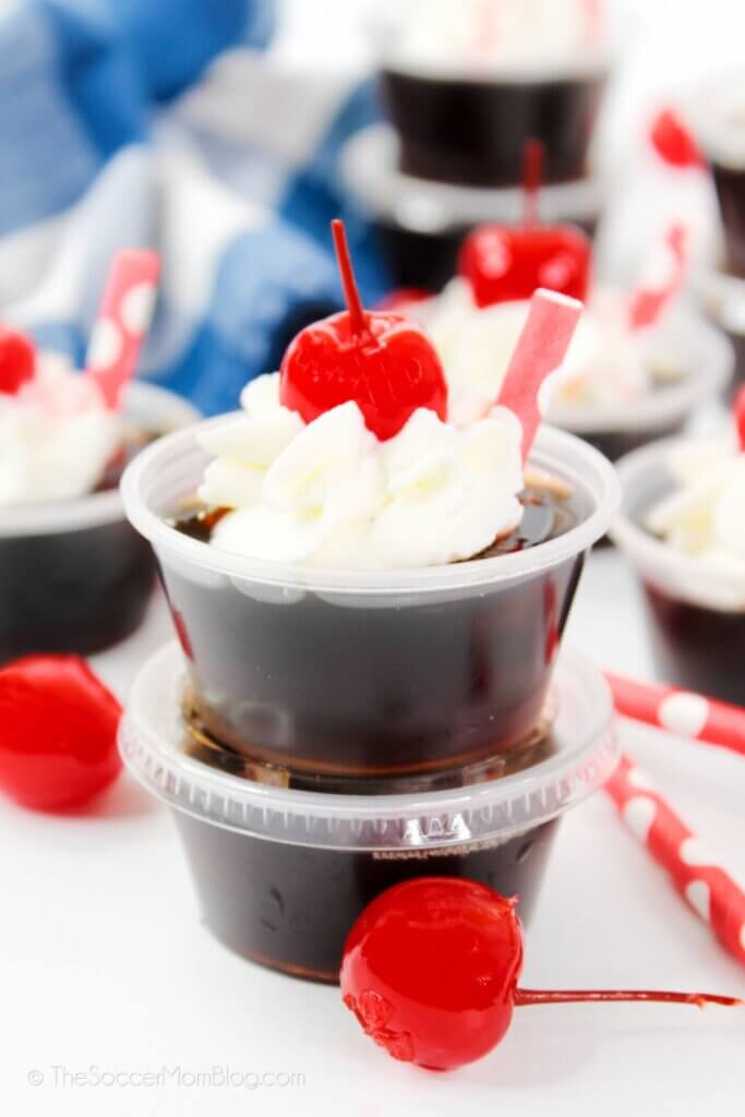 root beer float jello shots with whipped cream and a cherry on top
