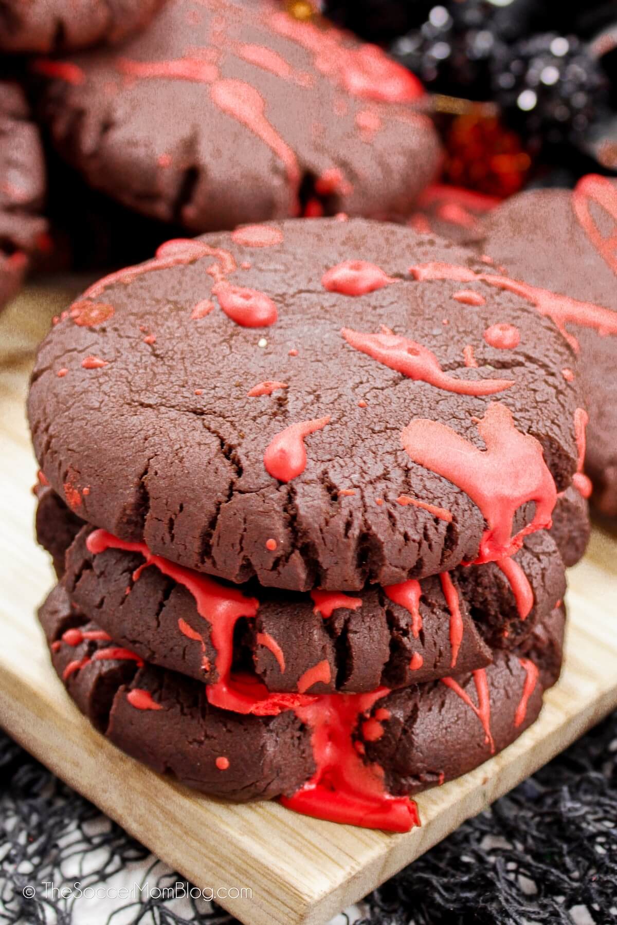 stack of three chocolate cookies with red frosting that looks like blood (for Halloween).