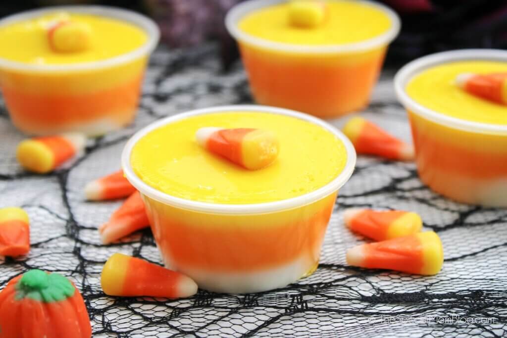 Candy Corn Jello Shots on a Halloween decorated table