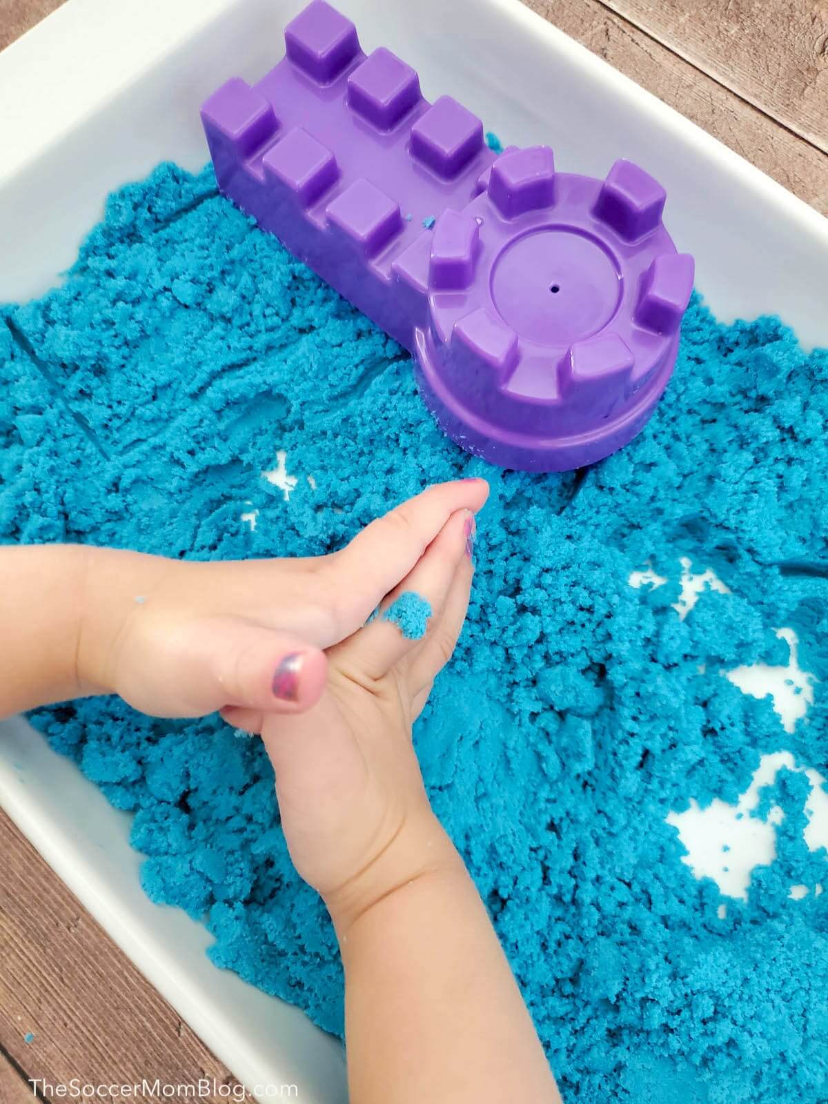 toddler's hands playing with sensory sand