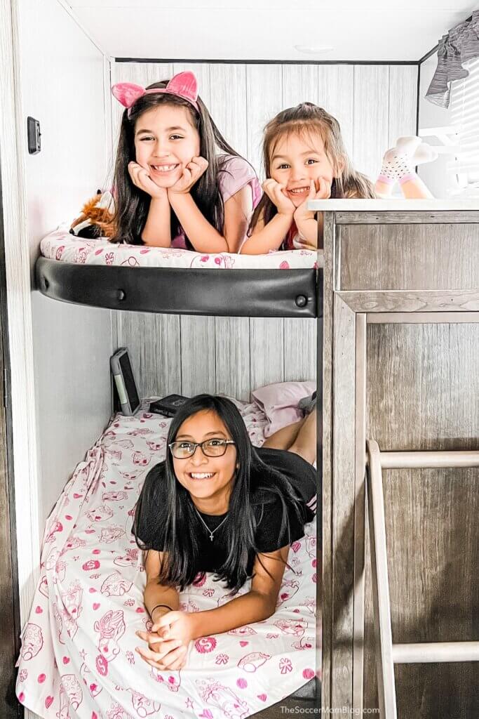 3 girls on bunk beds inside an RV