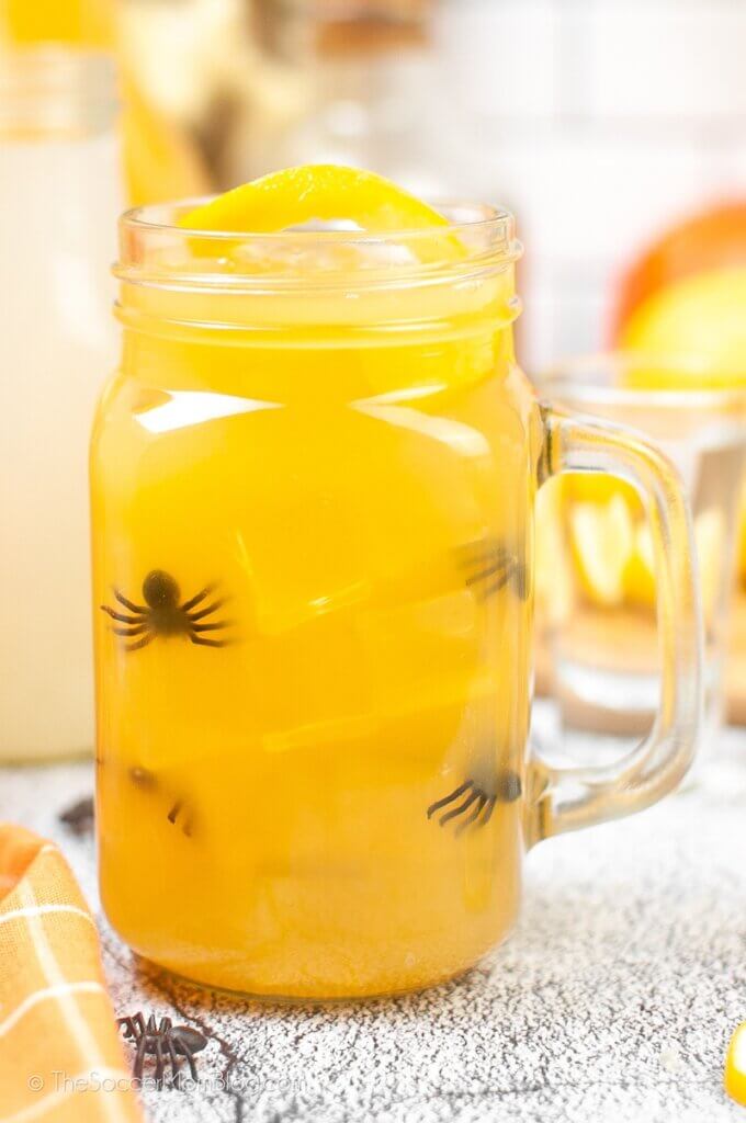 orange colored Halloween drink with spiders