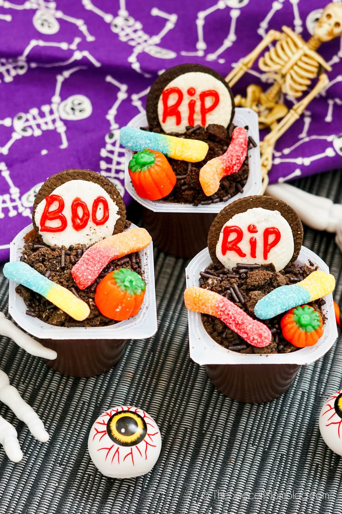chocolate pudding cups decorated to look like a graveyard with candy and cookies