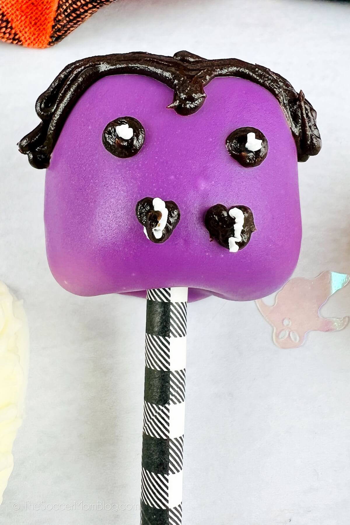 purple marshmallow pop decorated to look like Dracula