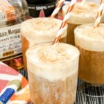 4 root beer floats with bottle of root beer and bottle of rum in background