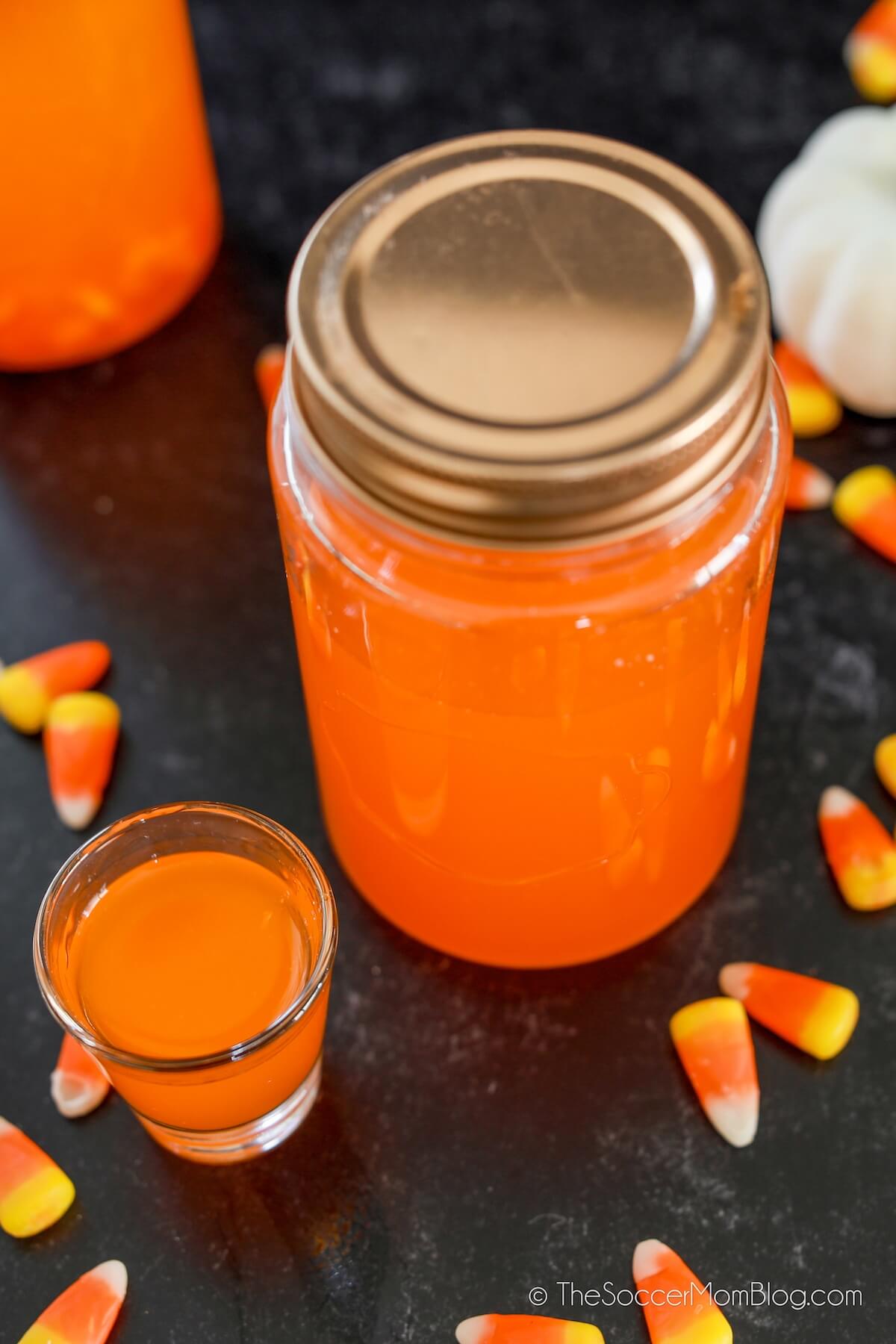 mason jar and shot glass with orange moonshine