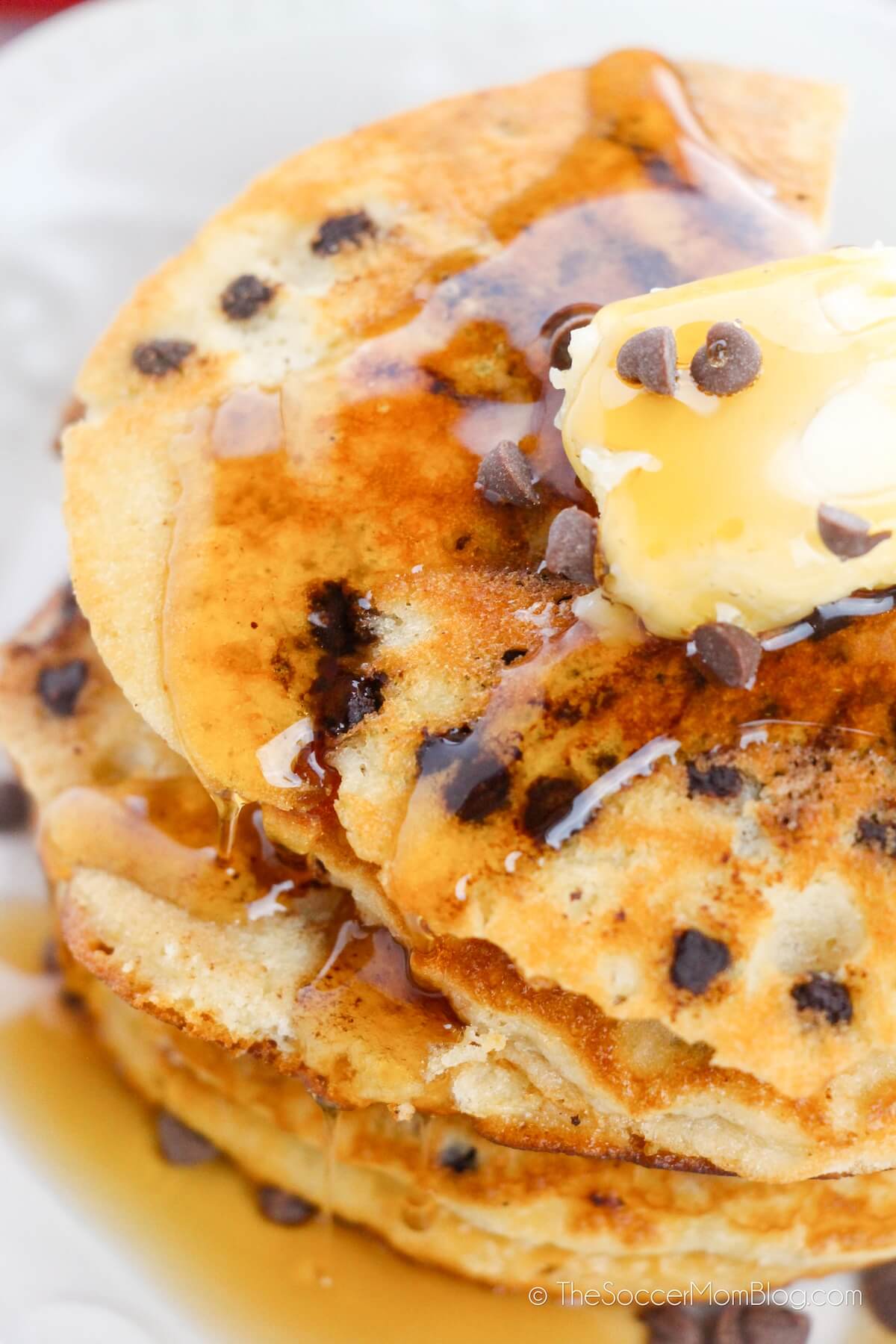 top down photo of chocolate chip pancakes with butter and syrup on top