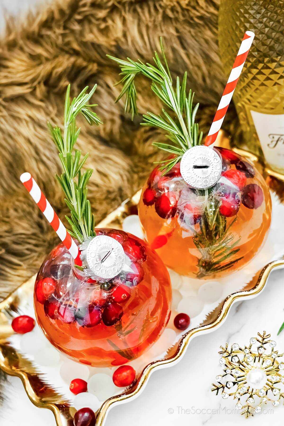 two clear ornaments filled with a Christmas cocktail