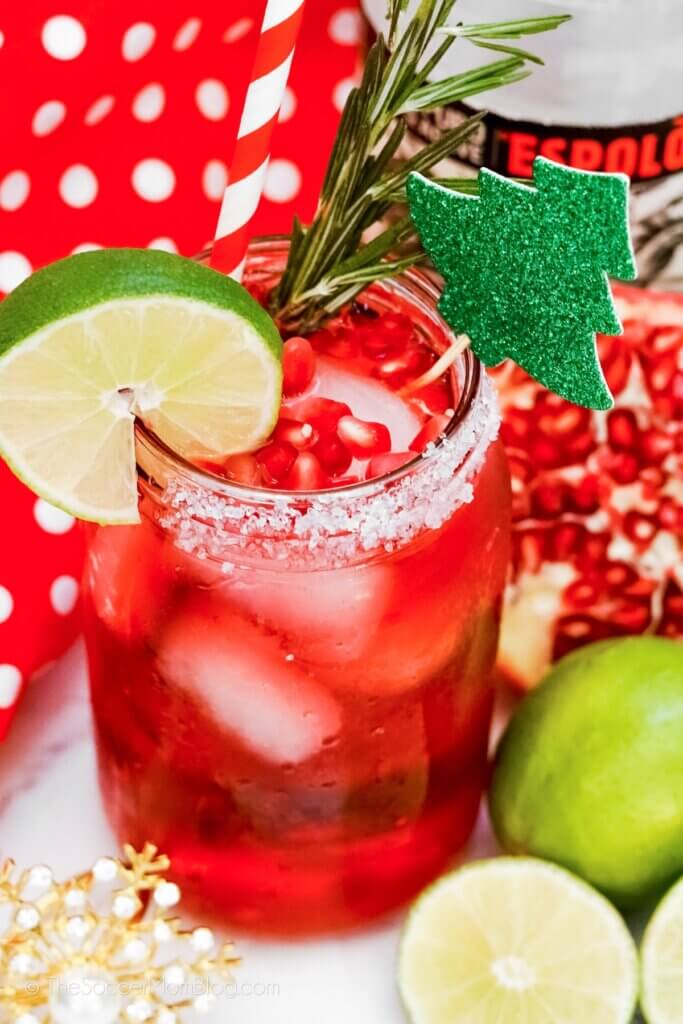 Close up of a Pomegranate Margarita, with real fruit and Christmas drink stirrer