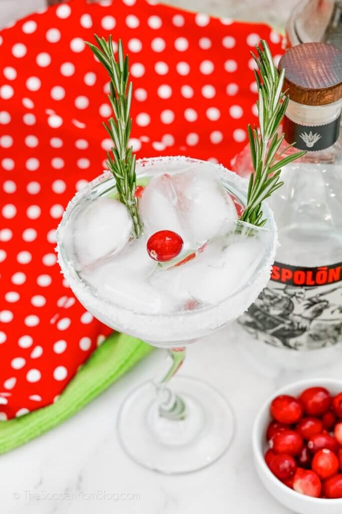 clear margarita with a cranberry and rosemary sprigs to lo0ok like Rudolph's nose and antlers