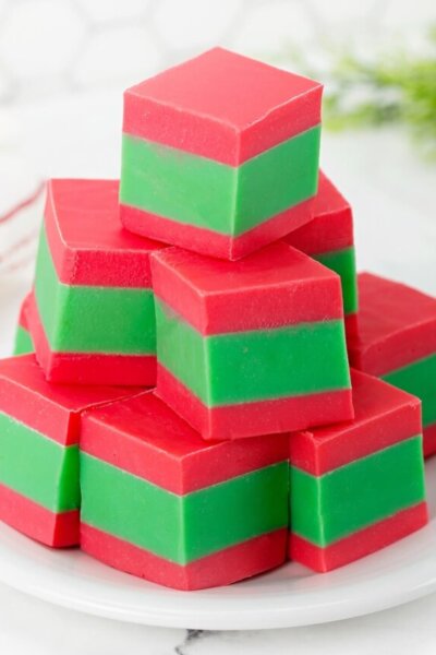 pile of red and green Christmas fudge squares on plate