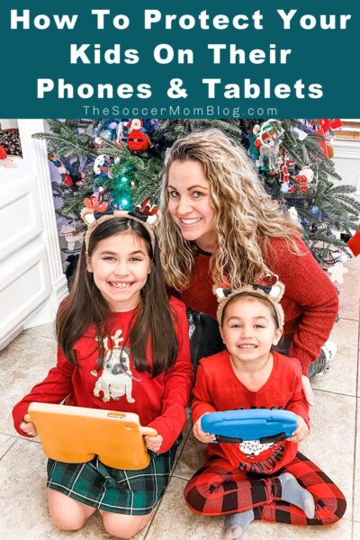 mom and two daughters using tablets in front of Christmas tree