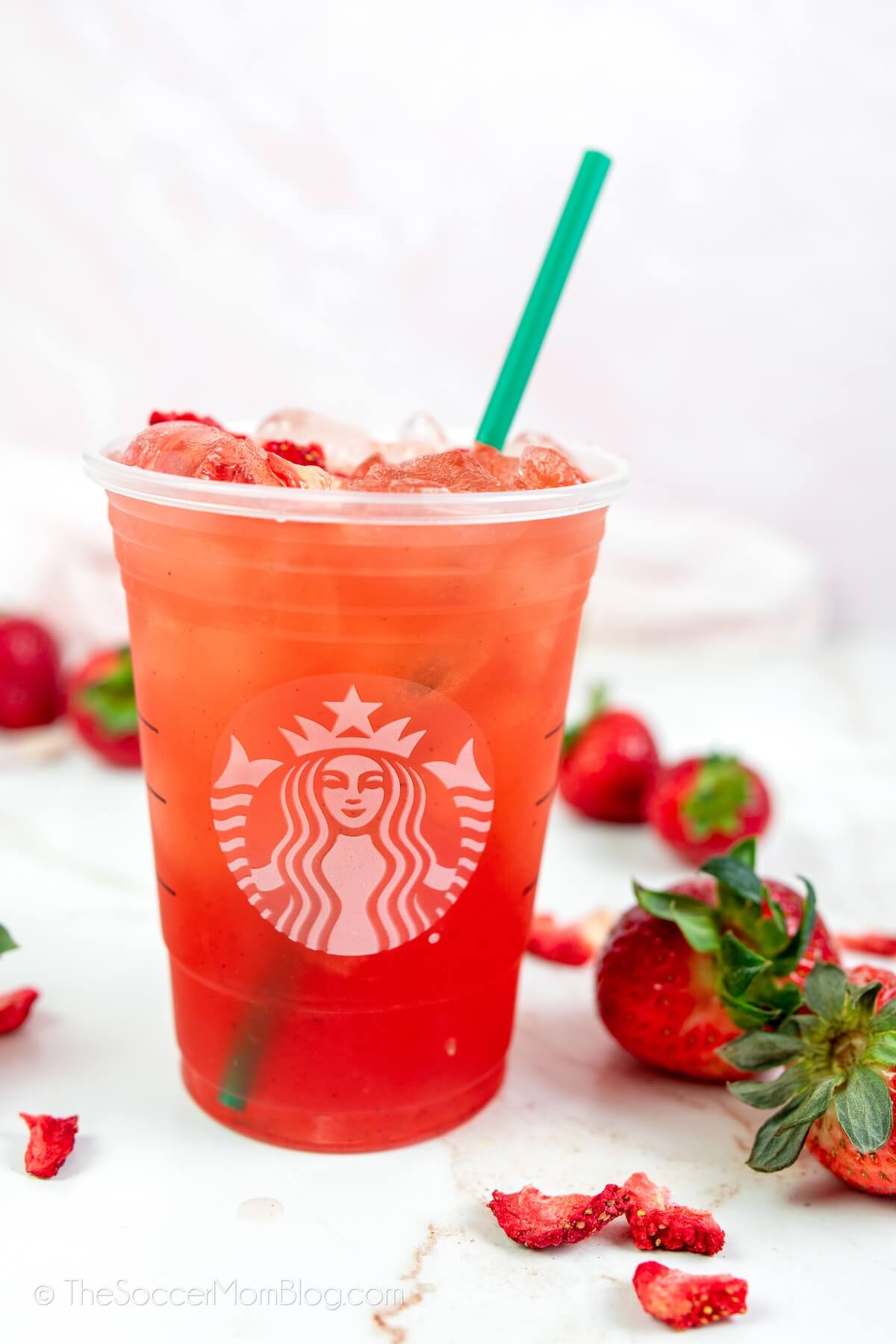 Starbucks strawberry acai refresher drink, surrounded by fresh berries