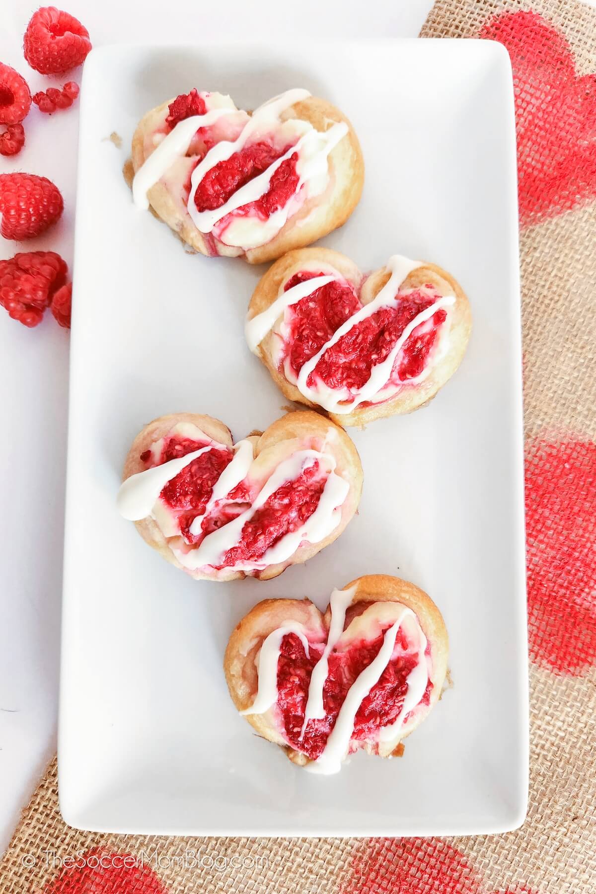 Four Raspberry Crescent Dough Hearts Danishes on a white plate