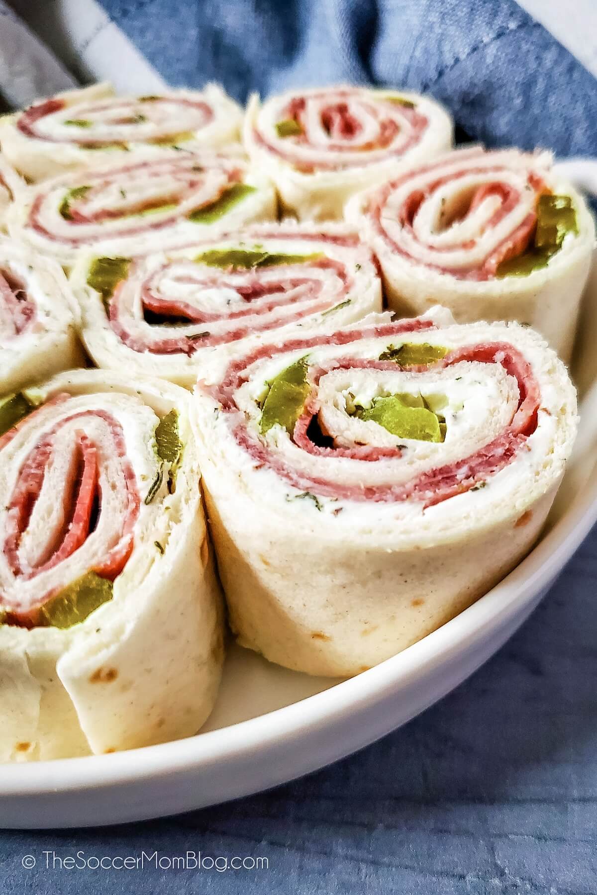close up of a plate filled with pickle pinwheels appetizer