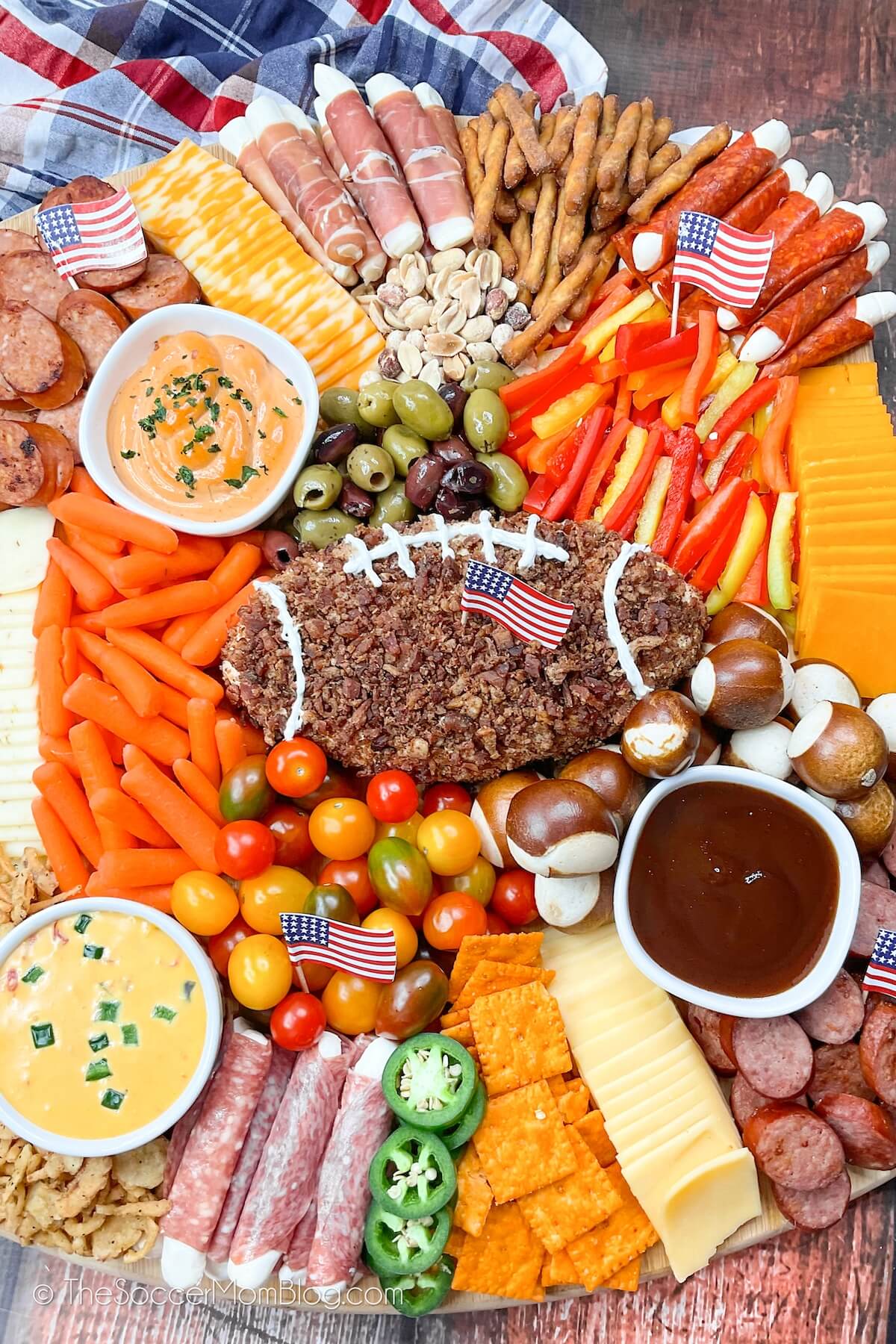 Football themed charcuterie board with a football shaped cheeseball in the middle