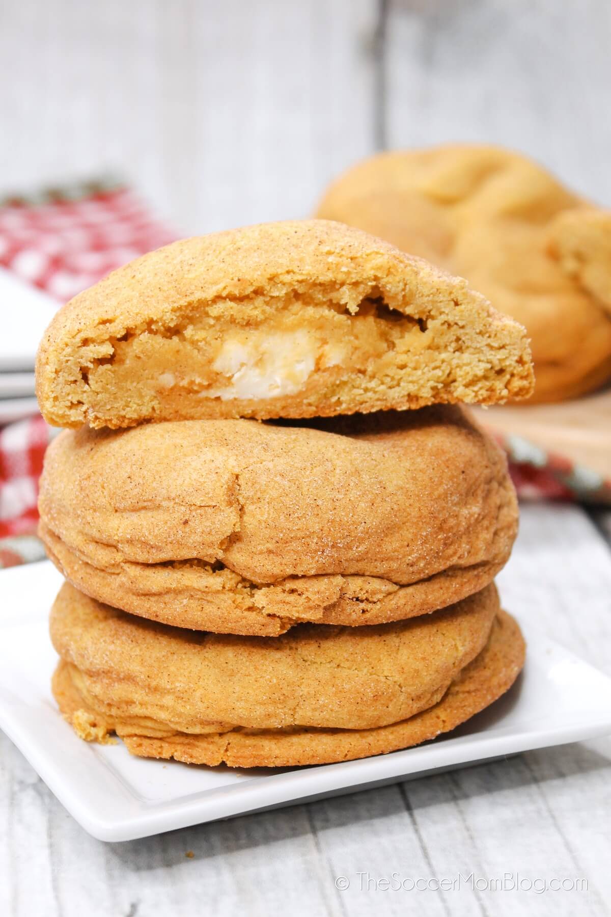 Pumpkin Cheesecake Cookies Stacked, with top cookie cut in half to show the filling