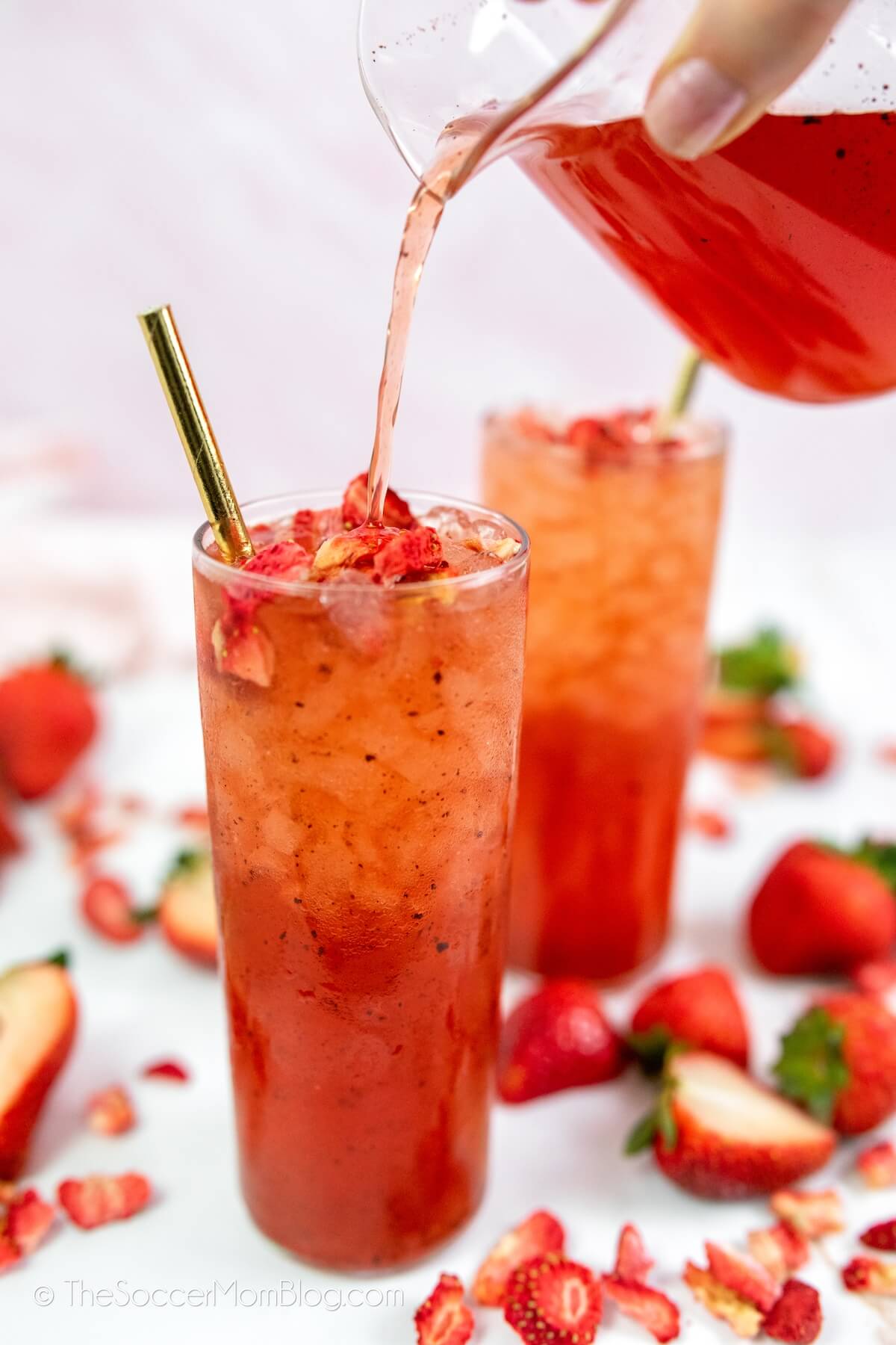 pouring strawberry drink into glass
