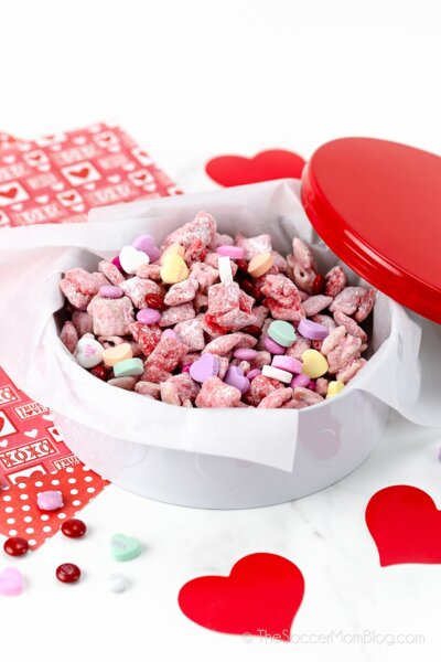 Valentine tin filled with red and pink candy coated Chex mix blended with conversation hearts