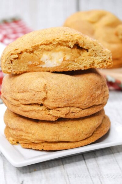 Pumpkin Cheesecake Cookies Stacked, with top cookie cut in alf to show the filling