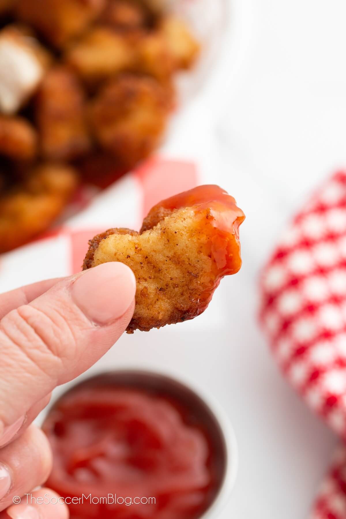 close up of a chicken nugget dipped in ketchup
