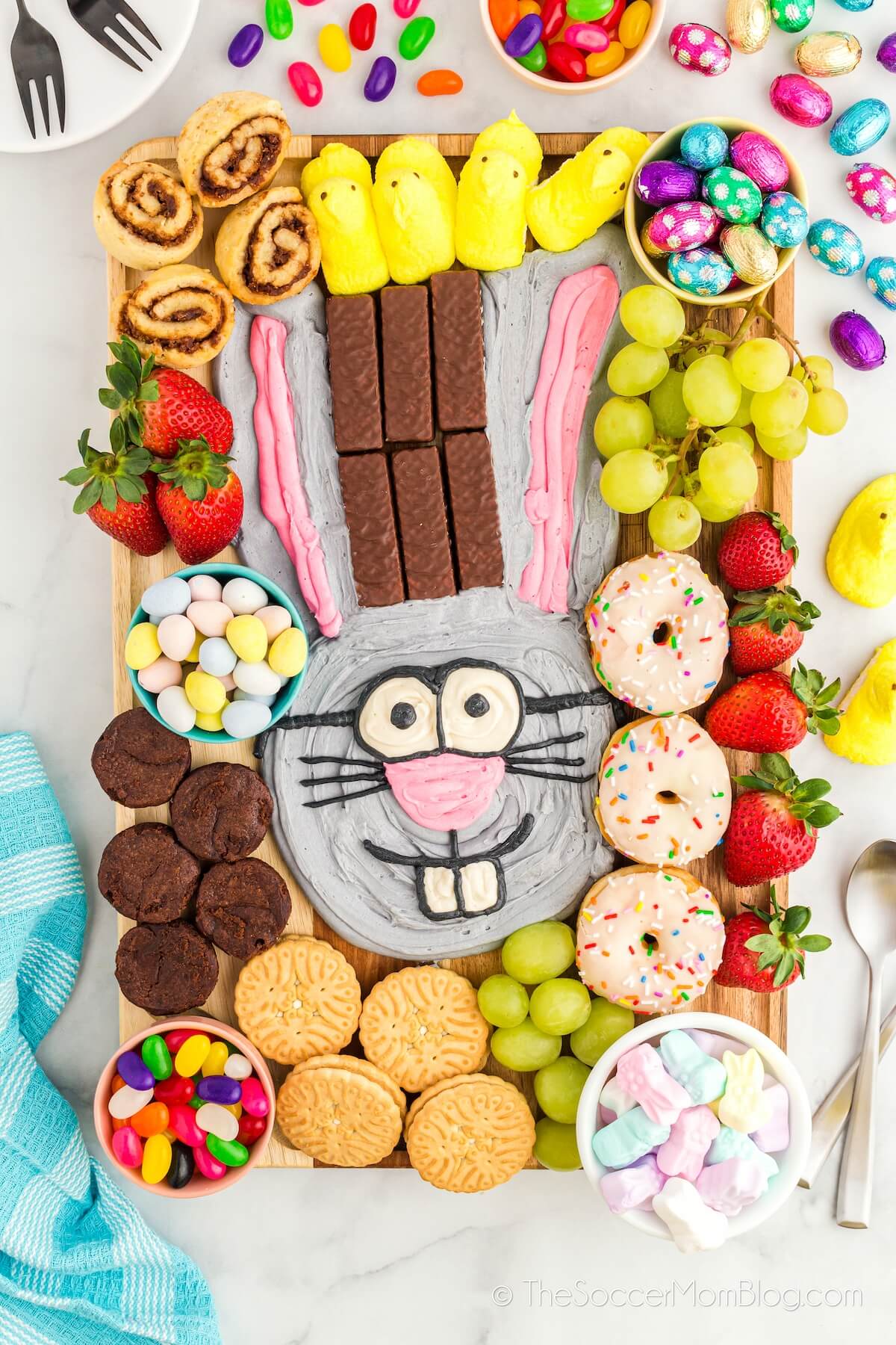 Easter dessert charcuterie board featuring a bunny made from frosting and sweets for dipping