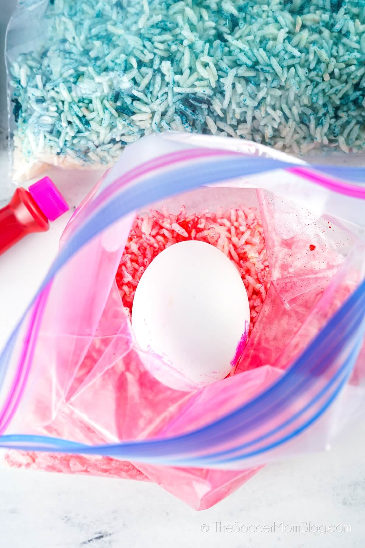 white egg in a bag of colored pink rice