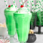two bright green homemade Shamrock Shakes with St. Patrick's Day decor