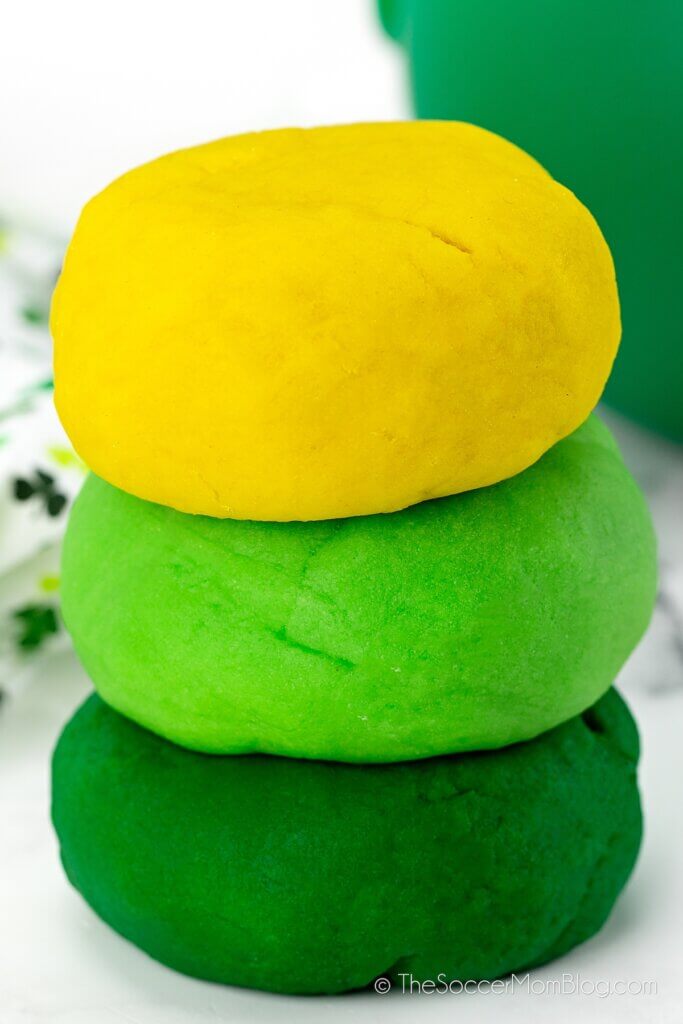 St. Patrick's Day playdough, green and gold playdough balls stack on top of each other