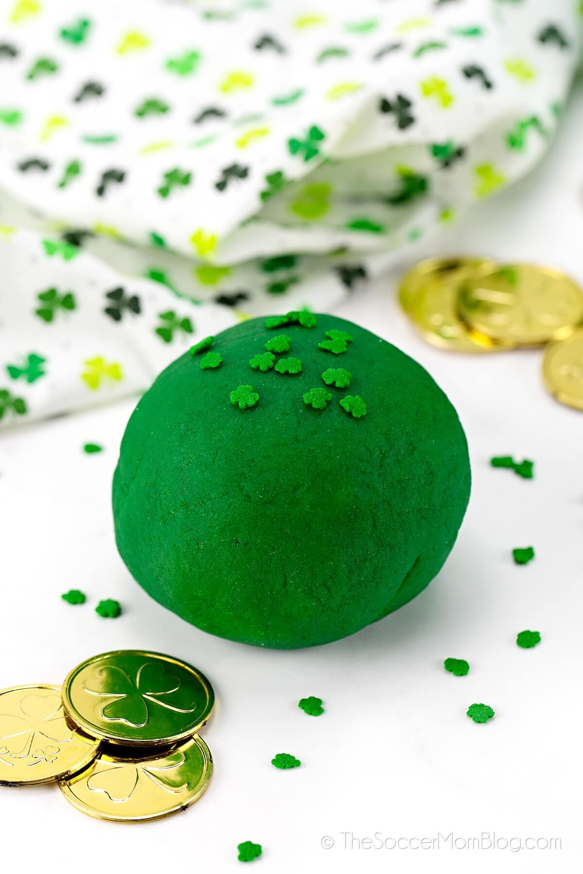 ball of dark green playdough with shamrock sprinkles on top